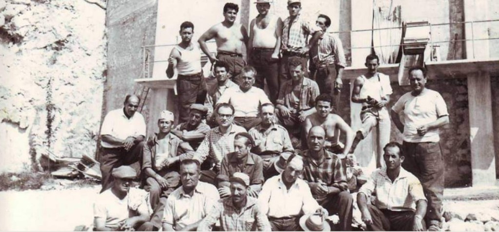 Immagine di gruppo degli operai della ex Cava CIDI di Marcellina. Alcuni operai posano davanti alla cava di pietre calcaree da cui si produceva il cemento