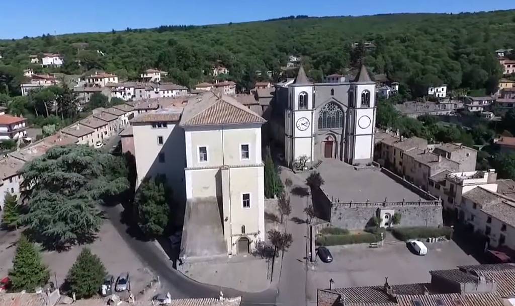 Vista aerea della piazza del Duomo e della Piazza dell'Oratorio nel borgo di San Martino al Cimino. In primo piano il Palazzo Doria Pamphilj e la Chiesa cistercense.